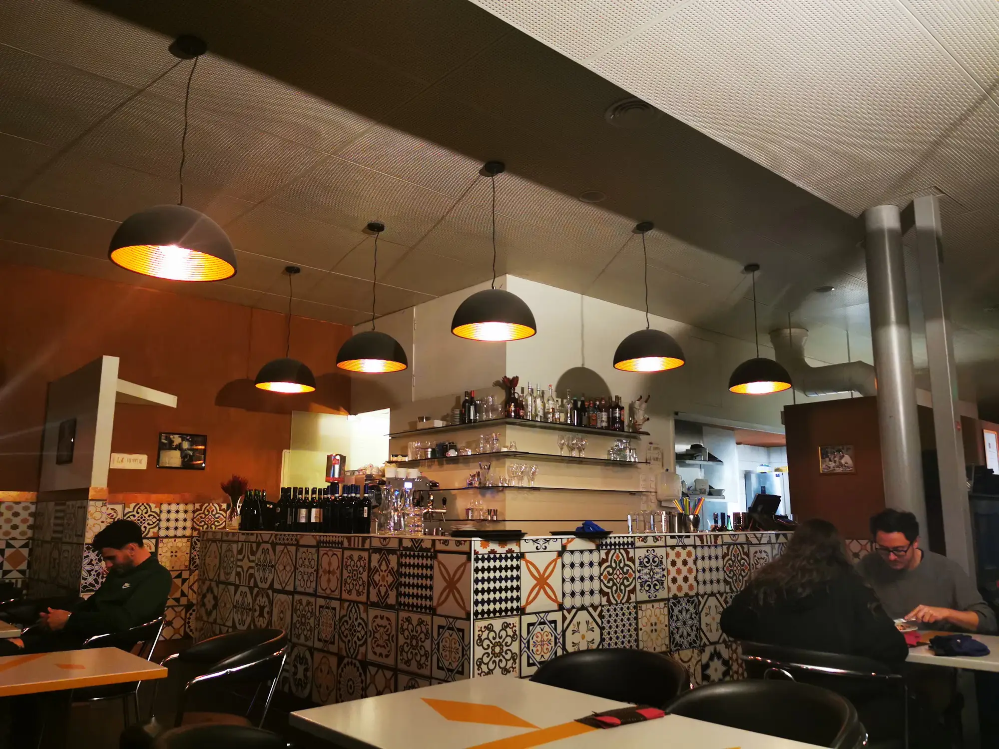 Bartheke mit gemusterten Fliesen und warmem Licht im Lokal