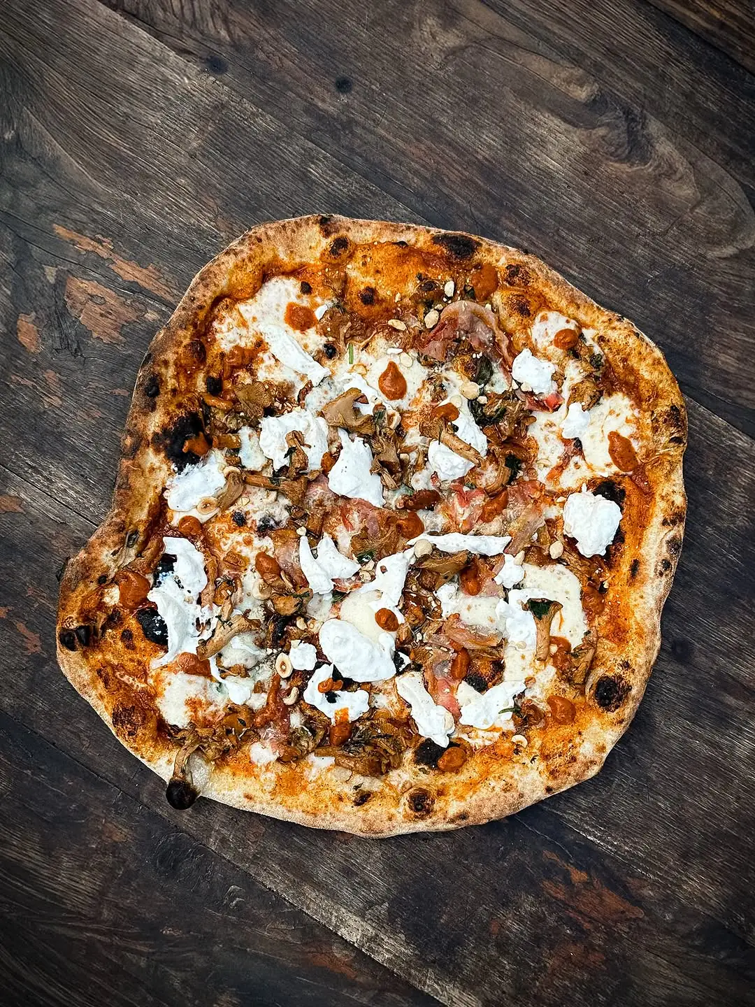 Holzofenpizza mit geschmolzenem Käse, Pilzen und frischer Burrata